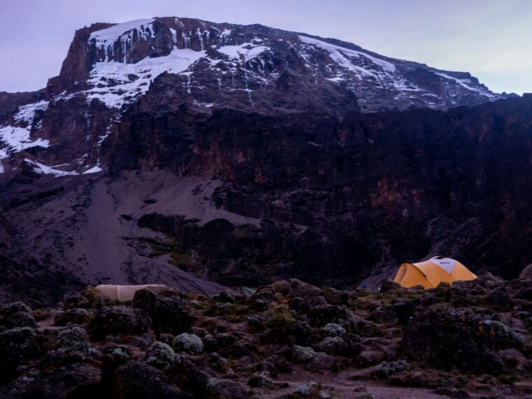 A tent at high camp with snow on the peak above